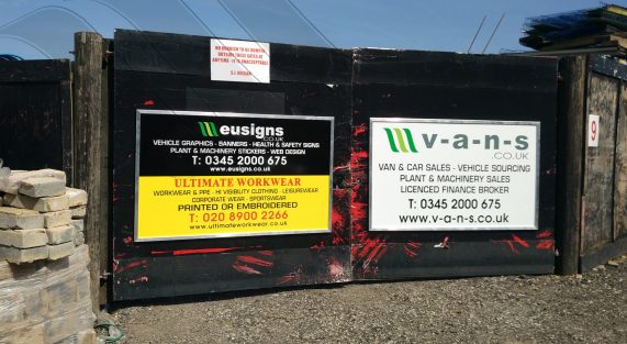 Vinyl signs on boards for commercial advertisement at the gates of a site entrance