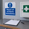 Accident reporting sign beside a blank incident record and first aid cabinet in a workplace reporting area